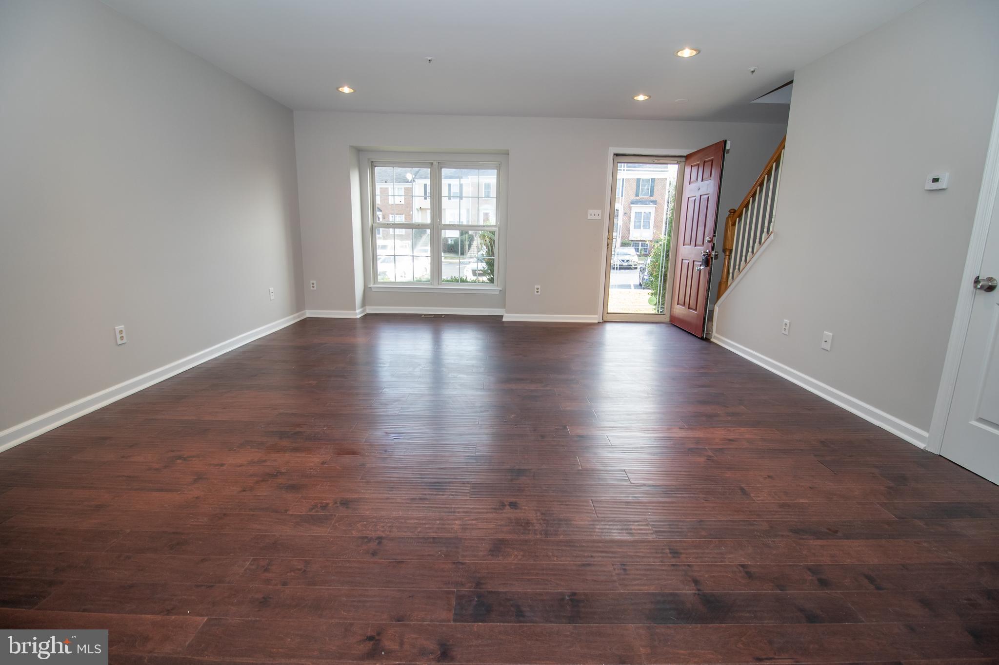 7708 Scatteree Road Severn, MD 21144 - Photo 5 of 41 an empty room with wooden floor and windows