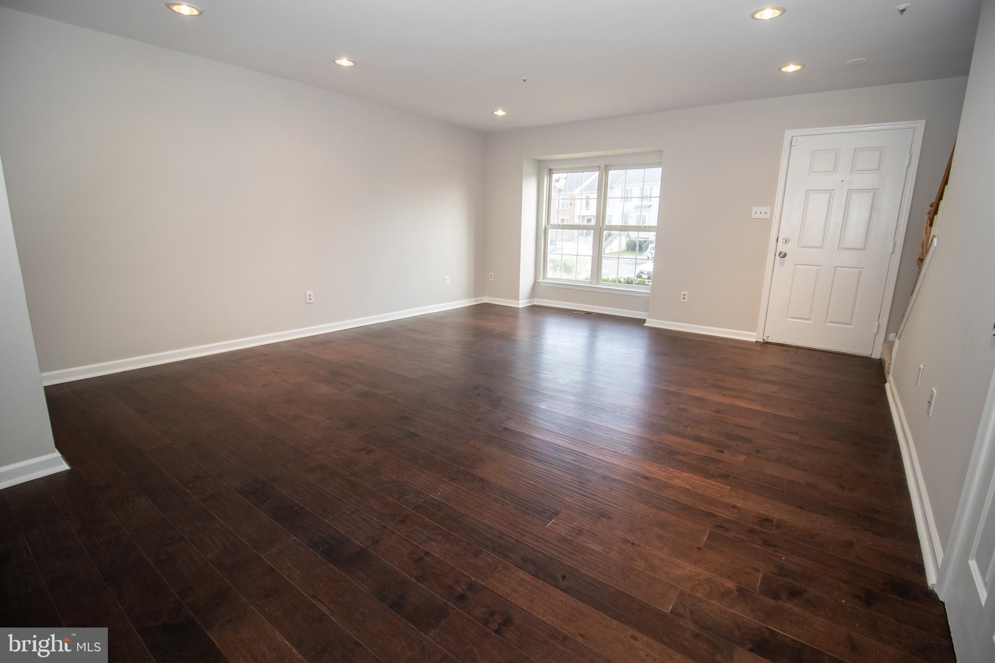 7708 Scatteree Road Severn, MD 21144 - Photo 6 of 41 an empty room with wooden floor and windows
