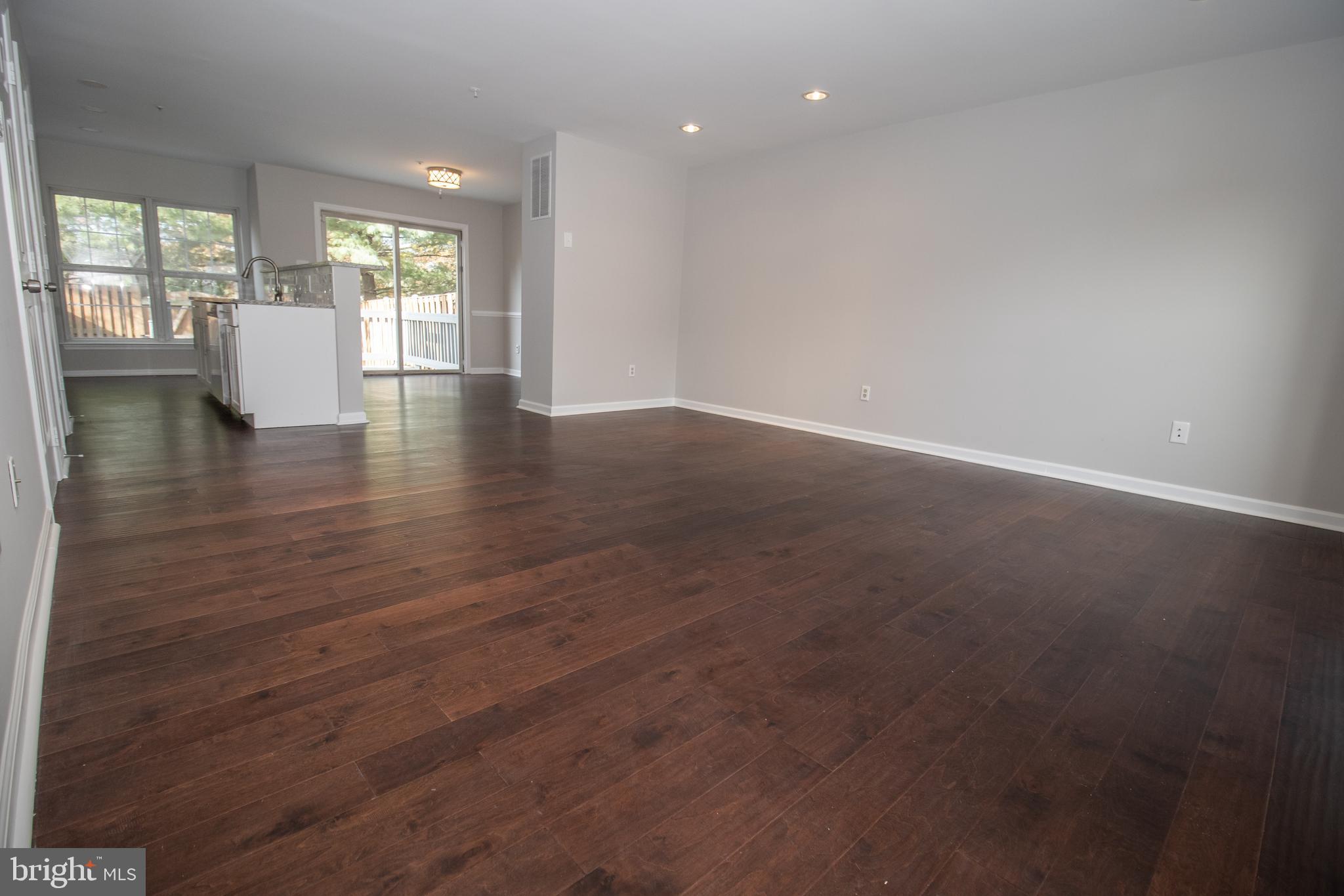 7708 Scatteree Road Severn, MD 21144 - Photo 7 of 41 an empty room with wooden floor and windows