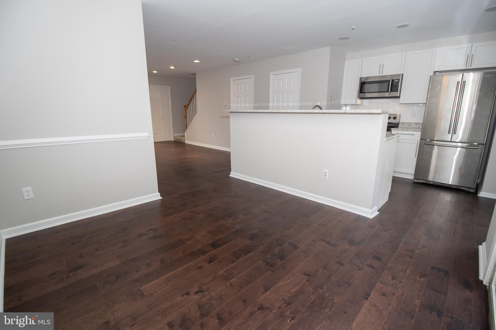 7708 Scatteree Road Severn, MD 21144 - Photo 9 of 41 a view of a refrigerator in kitchen and wooden floor