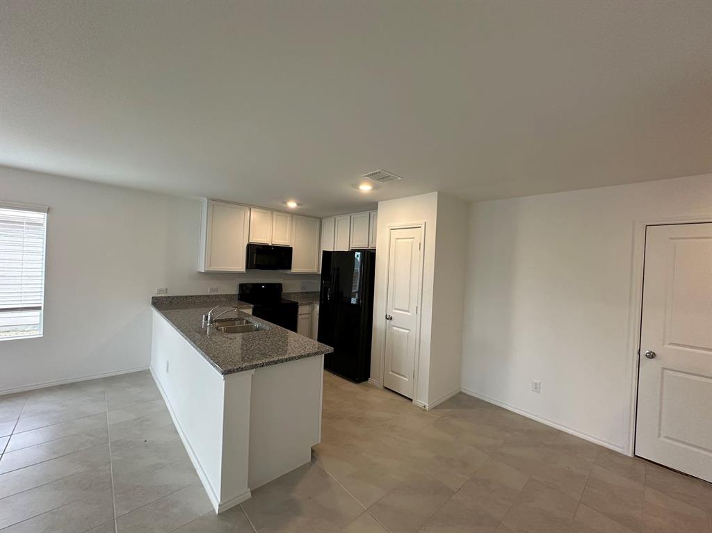 320 Dewberry Street Princeton, TX 75407 - Photo 12 of 19 a kitchen with refrigerator and microwave