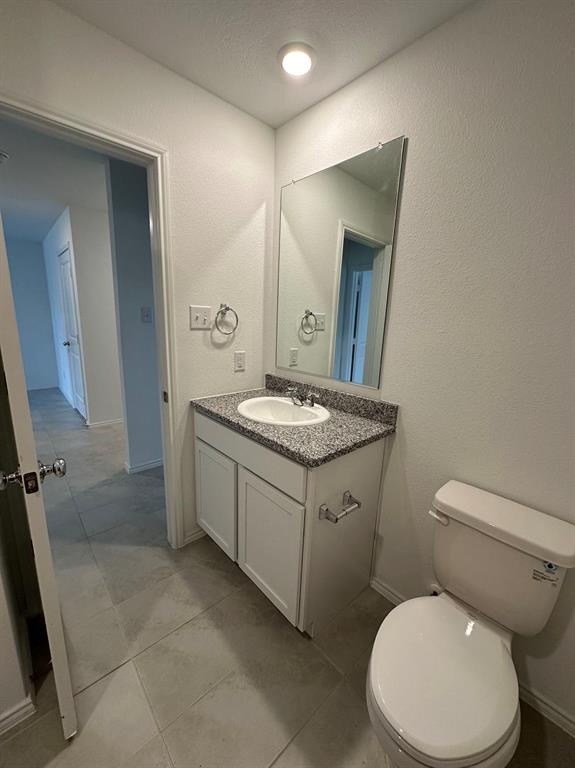 320 Dewberry Street Princeton, TX 75407 - Photo 15 of 19 a bathroom with a granite countertop toilet sink and mirror