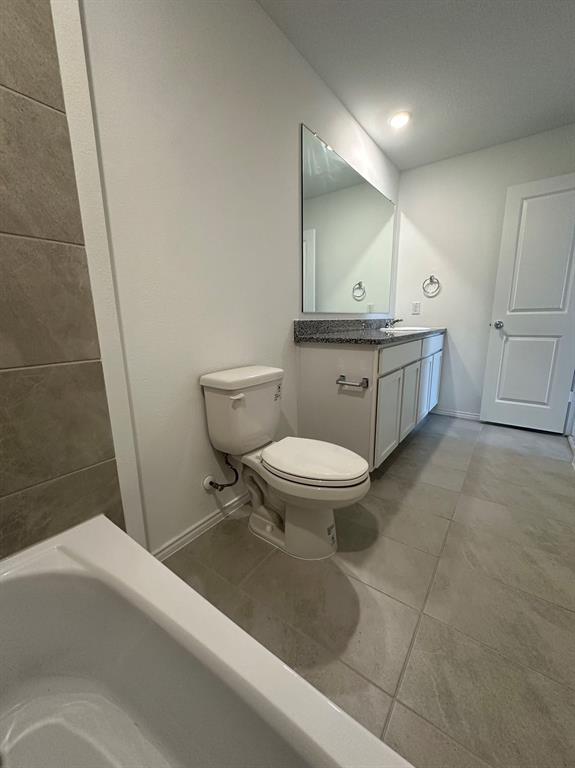 320 Dewberry Street Princeton, TX 75407 - Photo 10 of 19 a bathroom with a toilet a sink and mirror