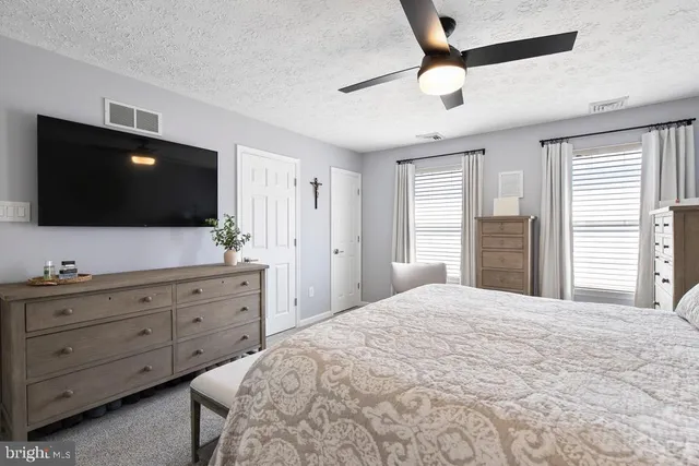 a bedroom with a bed a window and a flat screen tv