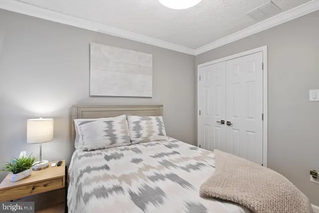 a bedroom with a bed and a lamp on the dresser