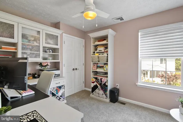a view of a workspace with furniture and a window