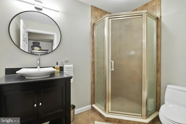 a bathroom with a sink a mirror a vanity and a shower