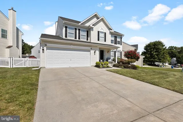 a front view of a house with a yard and potted plants