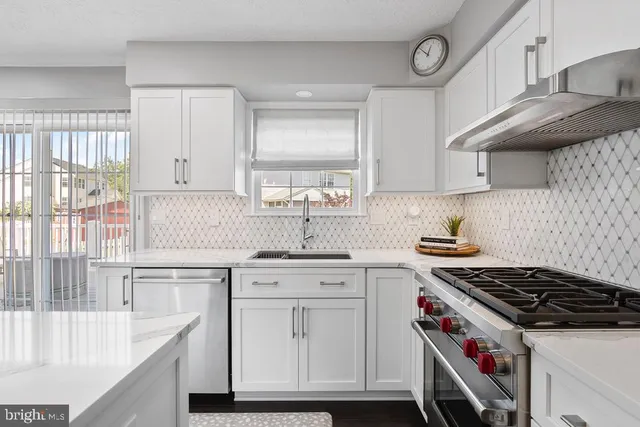 a kitchen with granite countertop a sink stove and cabinets