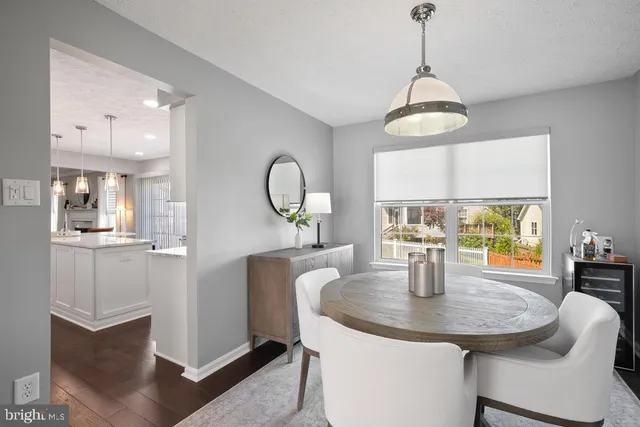 a dining room with wooden floor a chandelier a glass table and chairs