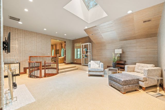 a living room with furniture a chandelier and a potted plant
