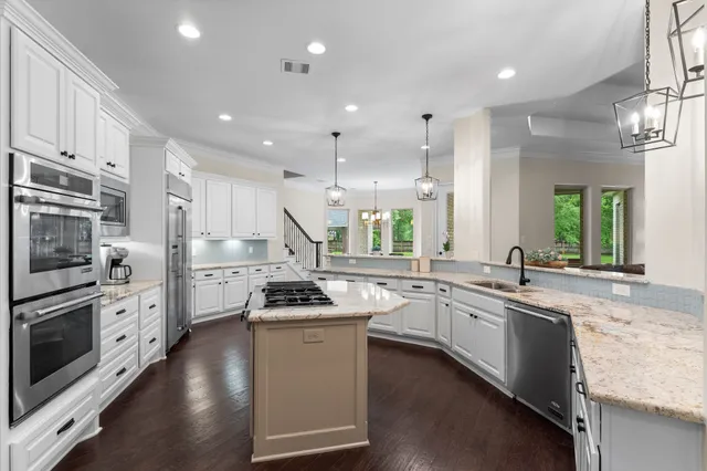 a kitchen with stainless steel appliances granite countertop a sink stove and refrigerator