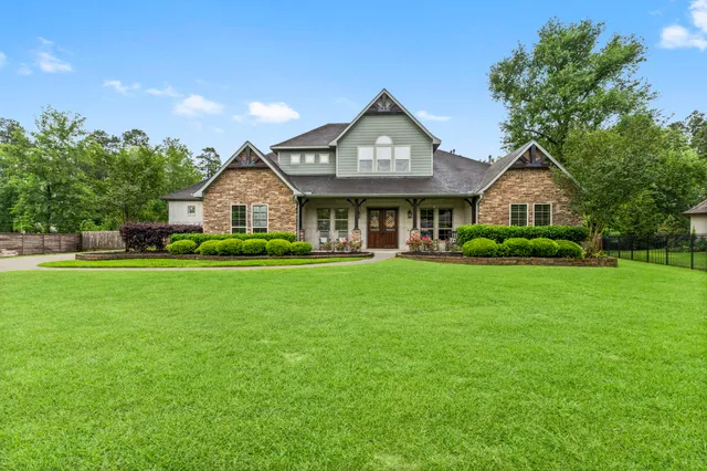 a front view of a house with a garden and trees