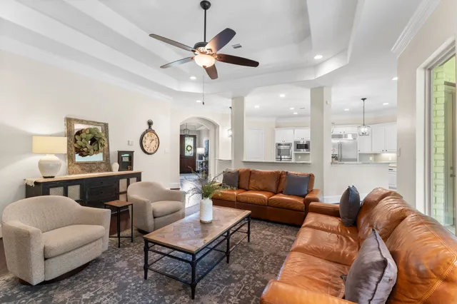 a living room with furniture kitchen view and a chandelier
