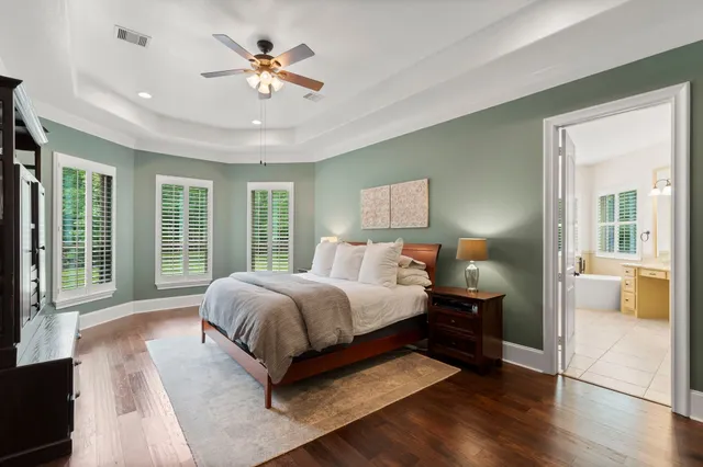 a spacious bedroom with a large bed and a chandelier