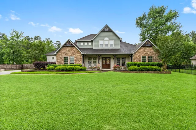 a front view of a house with a garden and trees