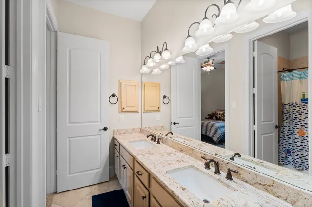 a bathroom with a granite countertop double vanity sink and a mirror