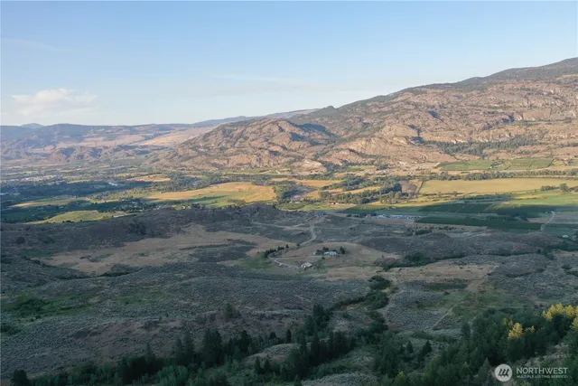 a view of a field with mountains in the background