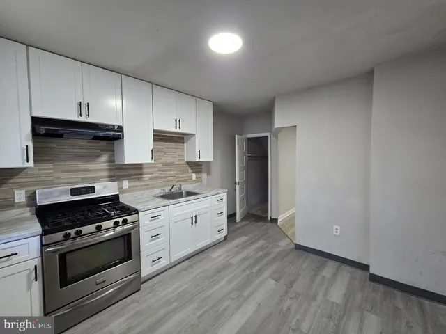 a kitchen with granite countertop a stove and a sink