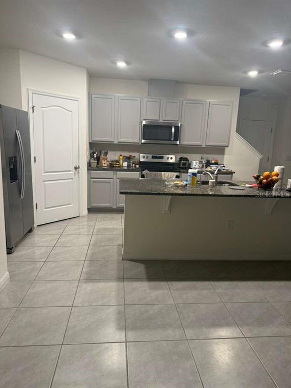 6847 Botanic Boulevard Harmony, FL 34773 - Photo 2 of 4 a kitchen with stainless steel appliances granite countertop a refrigerator and a stove