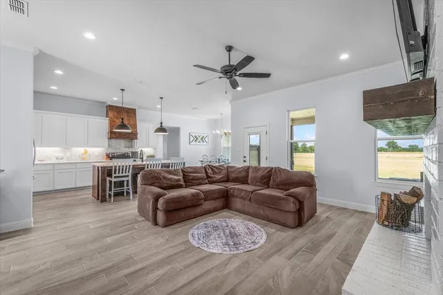 a living room with furniture a two couches and a dining table with wooden floor