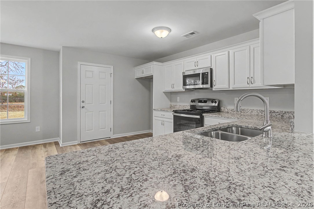 402 Rutherford Street Spring Lake, NC 28390 - Photo 14 of 34 a kitchen with granite countertop a sink cabinets and stainless steel appliances