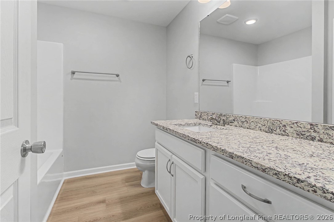 402 Rutherford Street Spring Lake, NC 28390 - Photo 23 of 34 a bathroom with a granite countertop sink and a toilet