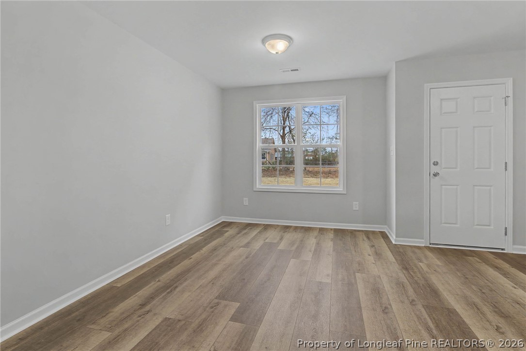 402 Rutherford Street Spring Lake, NC 28390 - Photo 9 of 34 an empty room with wooden floor and windows