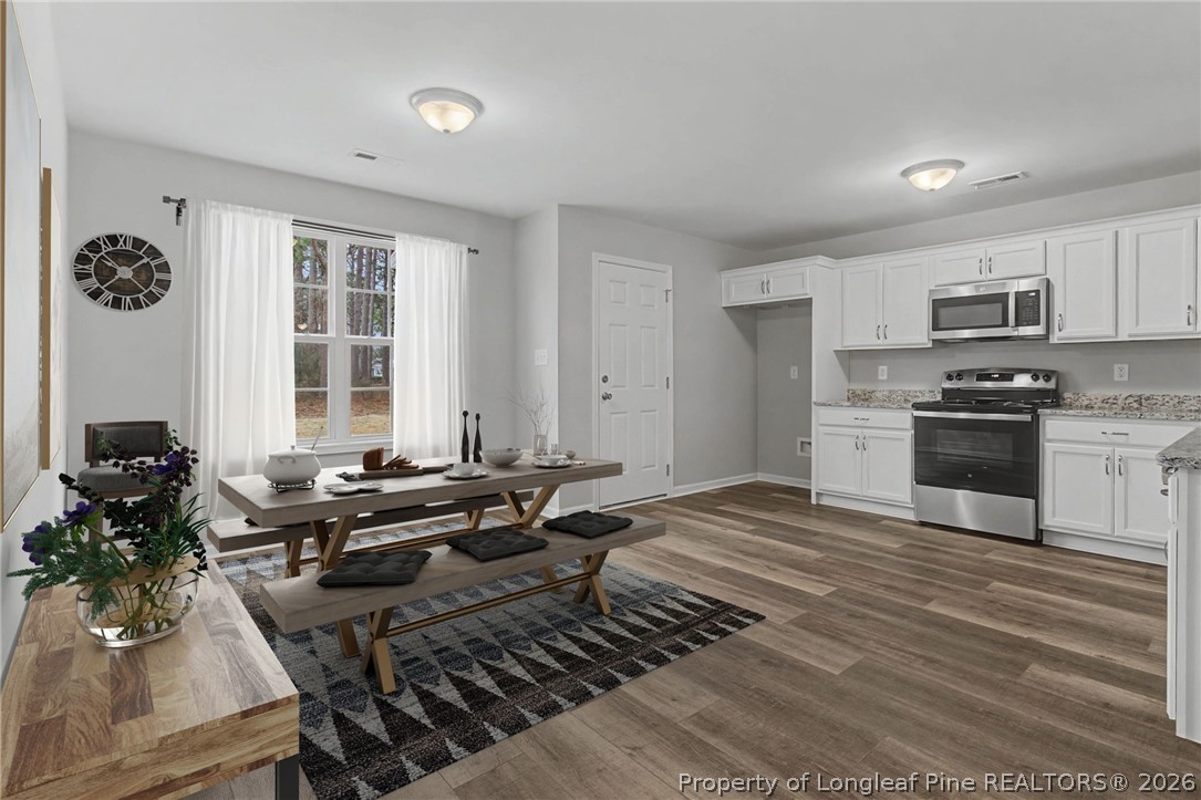 402 Rutherford Street Spring Lake, NC 28390 - Photo 10 of 34 a living room with furniture a dining table and large windows
