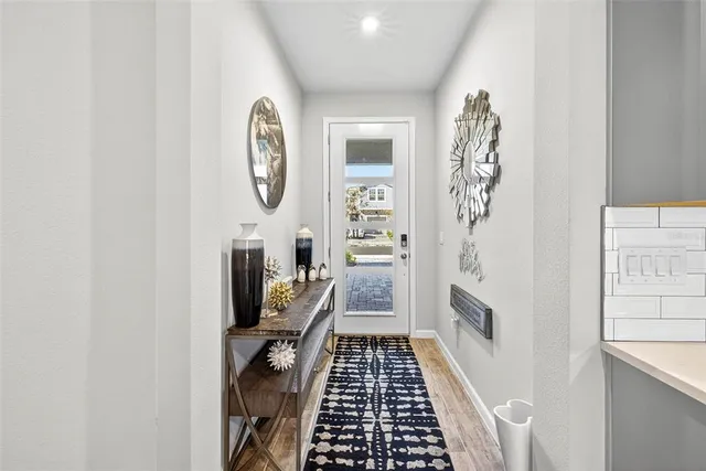 a view of a hallway with wooden floor and a bathroom