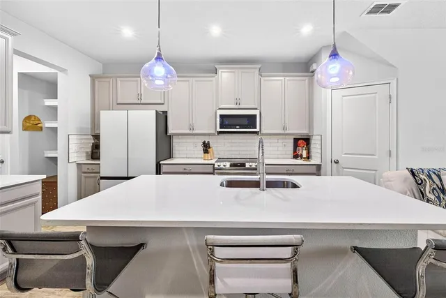 a kitchen with kitchen island a sink appliances and cabinets
