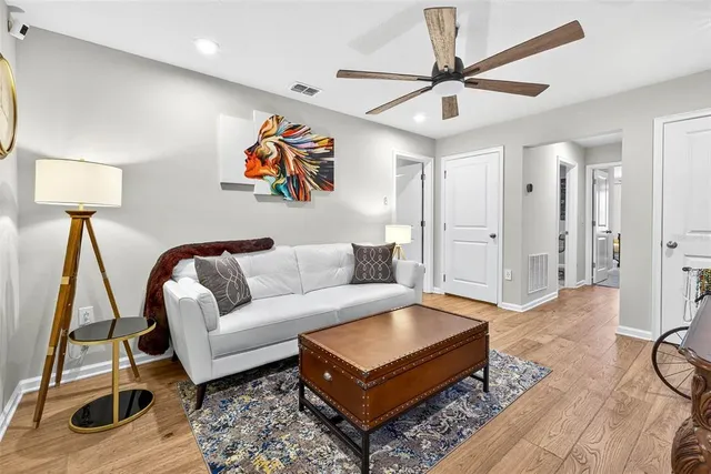 a living room with furniture and a wooden floor