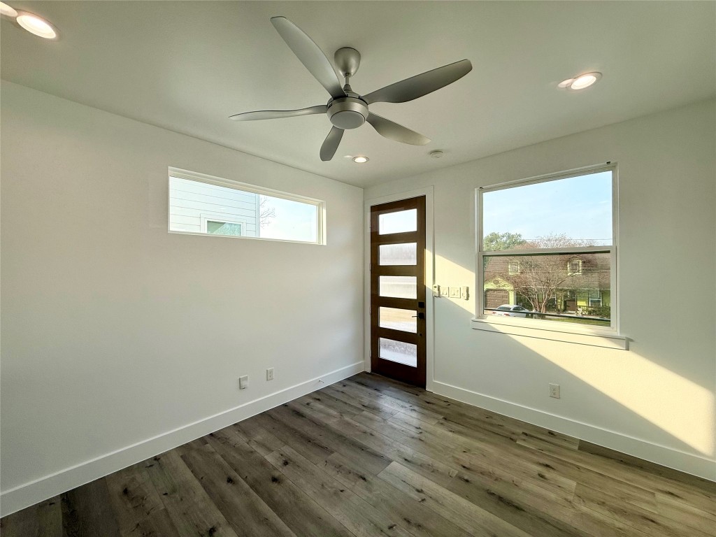 3919 East 16th Street, Unit 1 Austin, TX 78721 - Photo 7 of 11 an empty room with wooden floor fan and windows