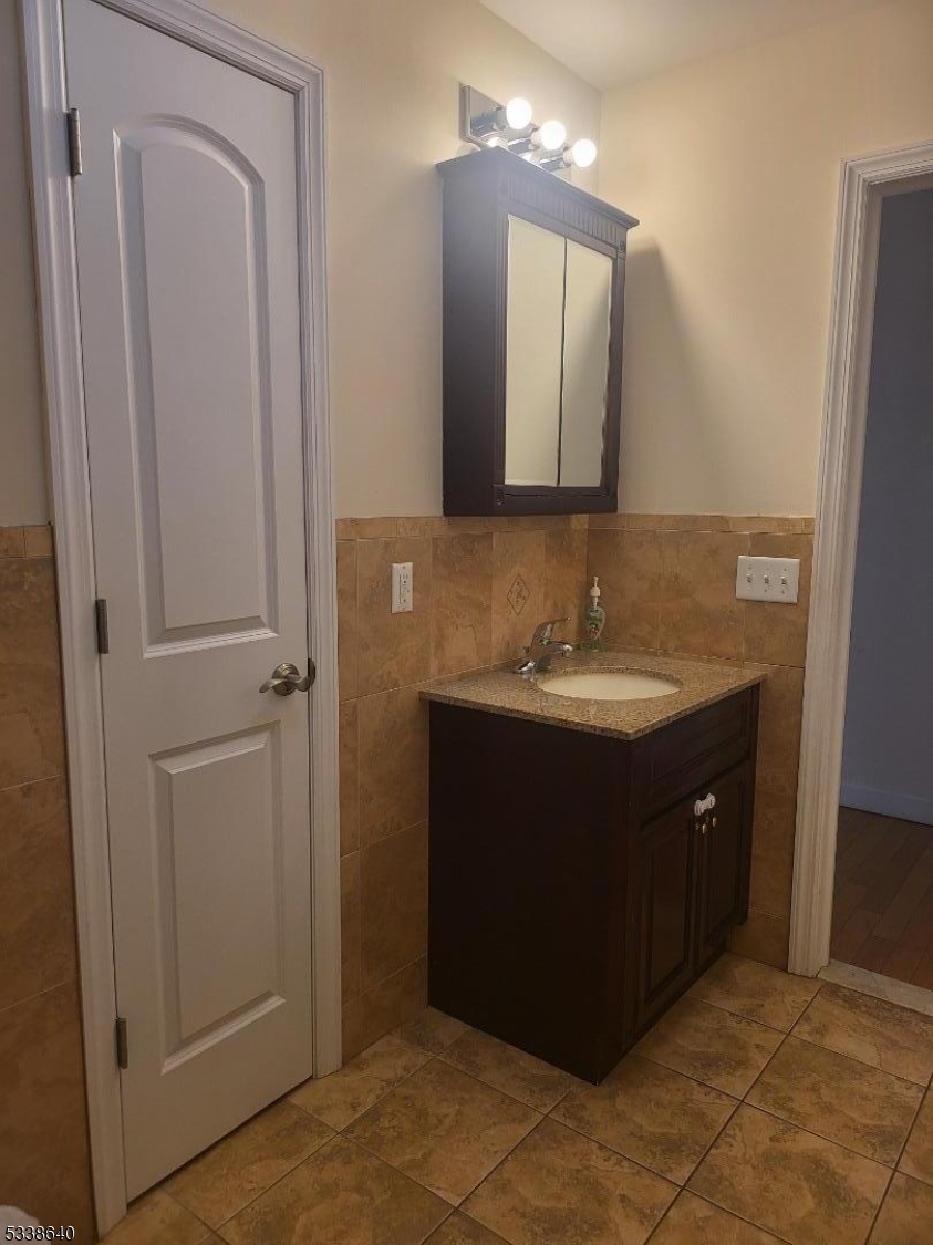 115 Ferry Street, Unit 3A Newark, NJ 07105 - Photo 8 of 10 a bathroom with a sink vanity and mirror