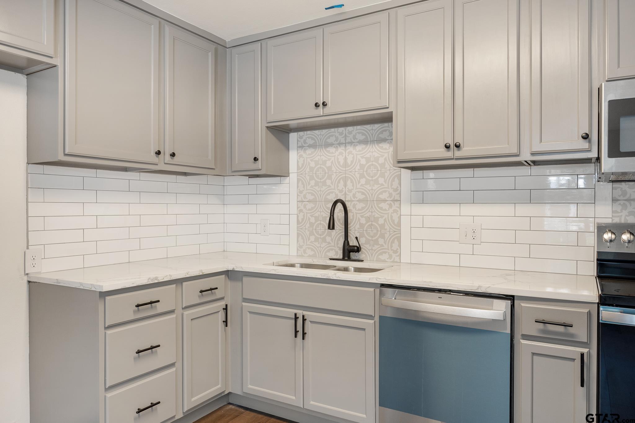 1538 North Hill Road Tyler, TX 75702 - Photo 11 of 29 a kitchen with white cabinets and white appliances
