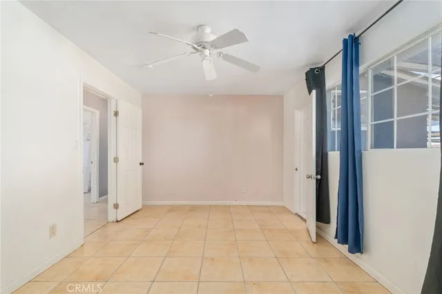 an empty room with closet and fan