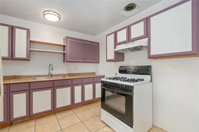 a kitchen with a sink cabinets and a wooden floor