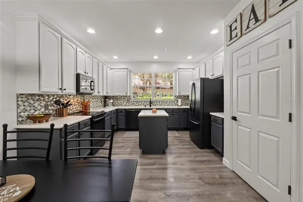 a kitchen with a refrigerator and a stove top oven