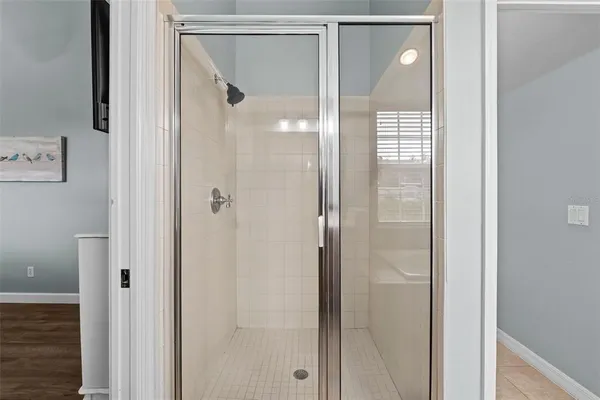 a bathroom with a glass shower door and a mirror