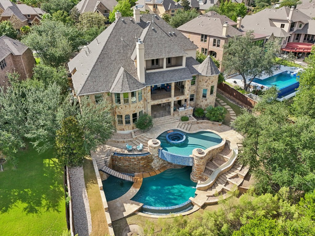 an aerial view of a house with table and chairs under an umbrella