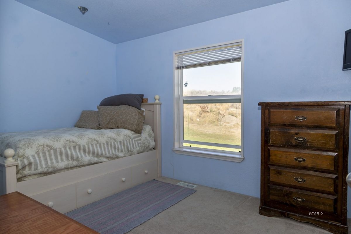 426 Spring Valley Parkway Spring Creek, NV 89815 - Photo 7 of 16 a bedroom with a bed and a window