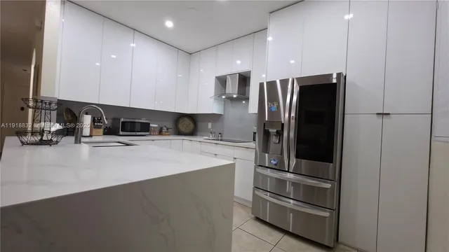 a kitchen with stainless steel appliances granite countertop a refrigerator and a stove