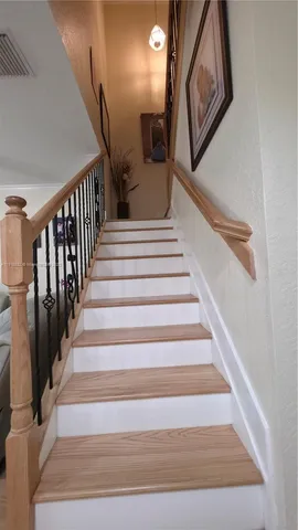 a view of a livingroom with wooden floor and a ceiling fan