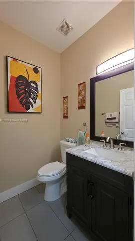 a bathroom with a granite countertop toilet a sink and mirror