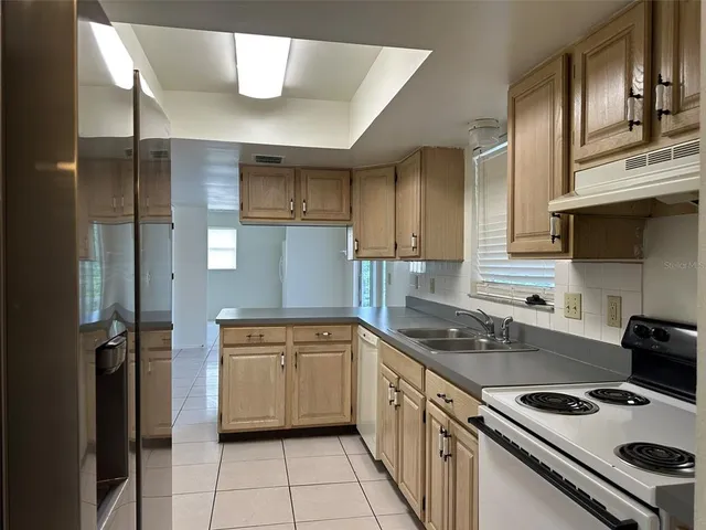a kitchen with a stove a sink and a refrigerator