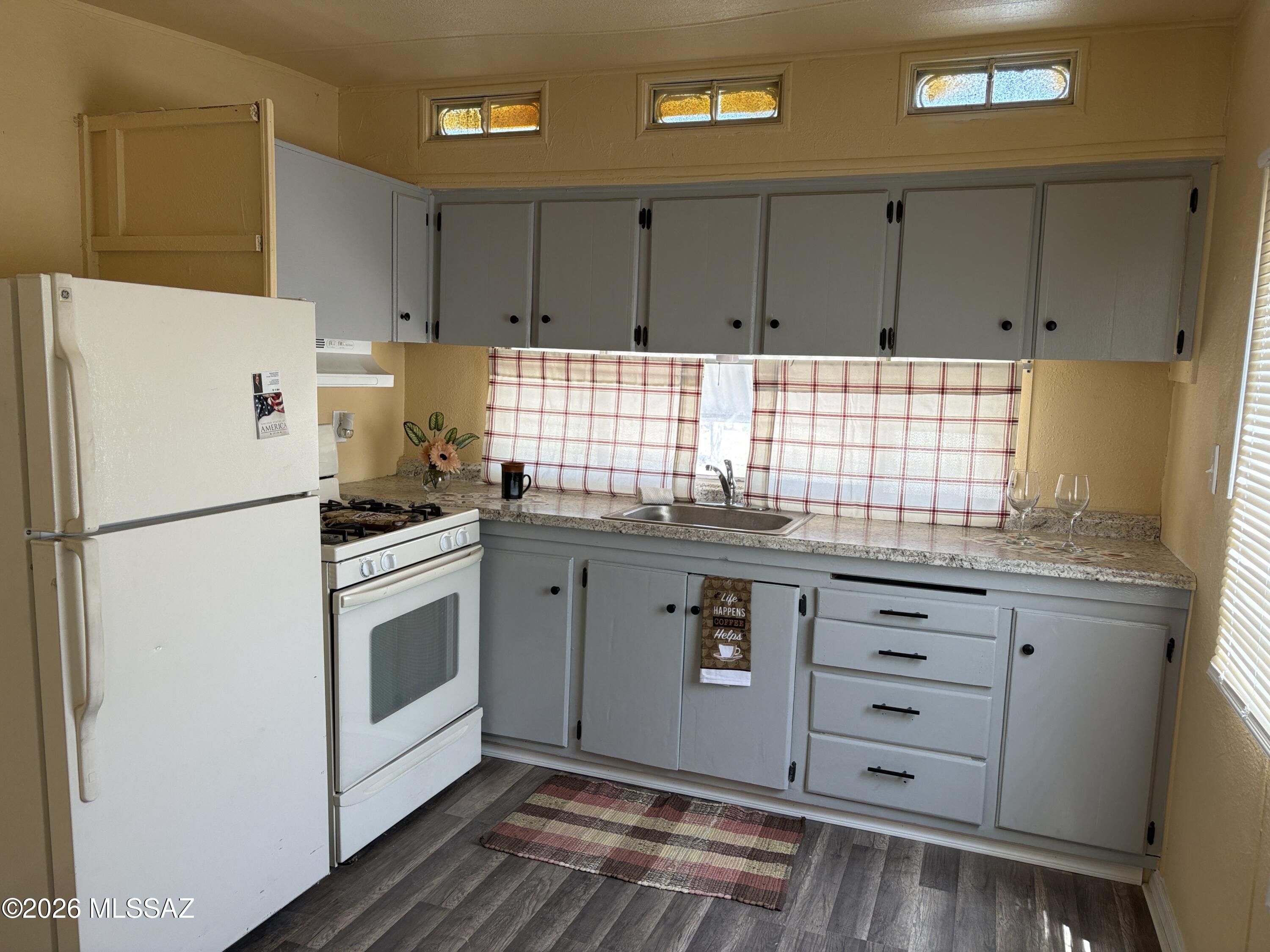 1741 West Wetmore Road, Unit 29 Tucson, AZ 85705 - Photo 3 of 10 a kitchen with granite countertop a refrigerator sink and cabinets