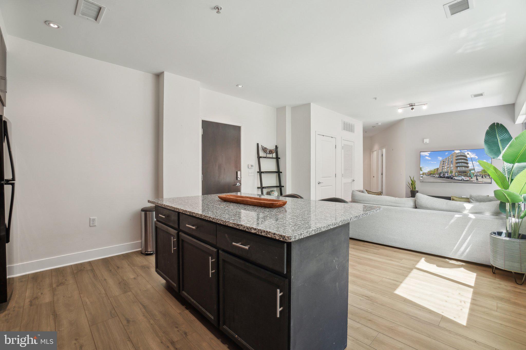 2550 17th Street Northwest, Unit 205 Washington, DC 20009 - Photo 4 of 25 a kitchen with granite countertop a sink and a stove top oven