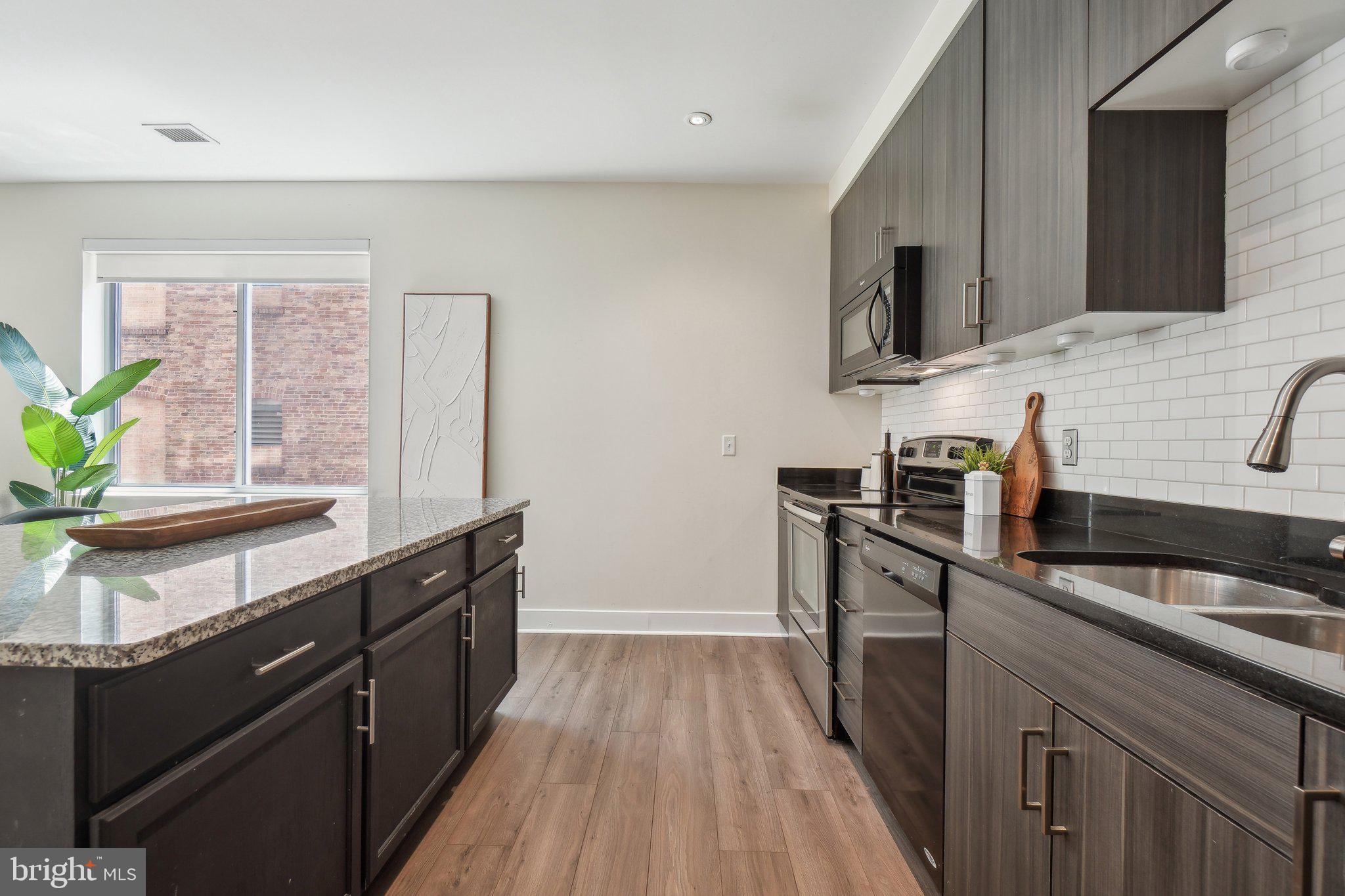 2550 17th Street Northwest, Unit 205 Washington, DC 20009 - Photo 10 of 25 a kitchen with granite countertop a sink stove and cabinets