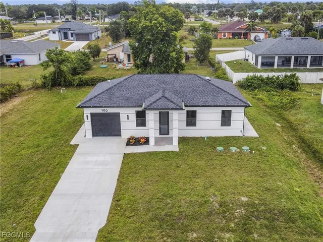 a aerial view of a house with swimming pool and a yard