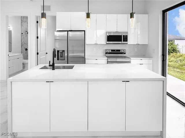 a kitchen with kitchen island white cabinets and refrigerator